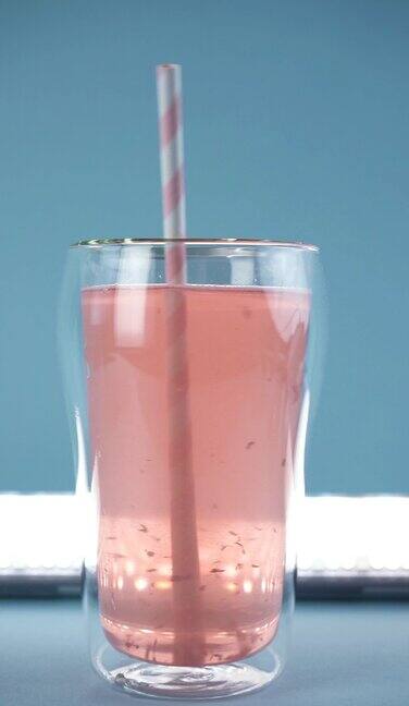 用粉色吸管在一杯水中搅拌胶原蛋白慢动作