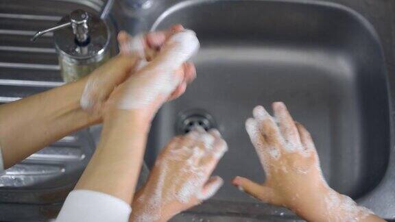 母亲教儿子在厨房洗手