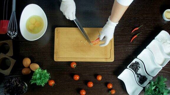前视图厨师在切菜板上切红辣椒胡萝卜删除种子