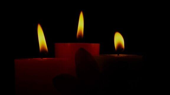 蜡烛火焰在风中轻轻摇曳在黑暗中燃烧的蜡烛旋转