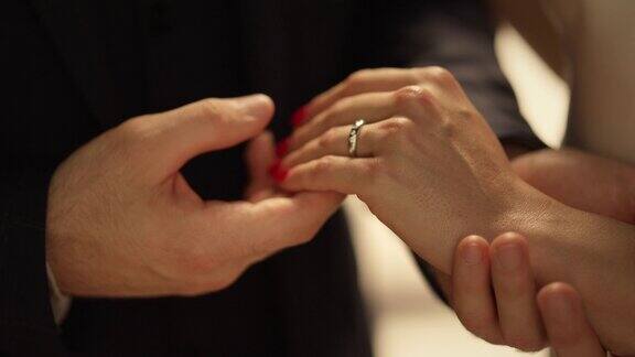 男人的手把戒指戴在女孩的手指上陌生男人牵着女人的手出门