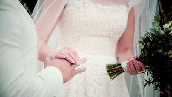 结婚那天新娘把金戒指戴在新郎的手指上交换结婚戒指的特写
