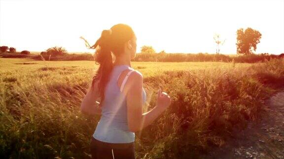 女慢跑者在日落边跑步边听音乐