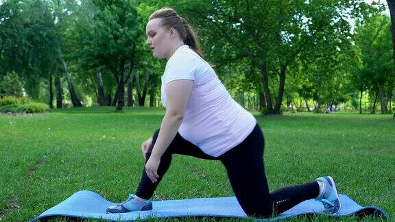 胖女孩在公园里伸展身体每天例行减肥渴望变苗条