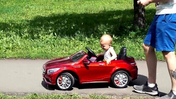 小男孩骑着爸爸开的玩具车