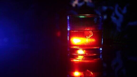 选择性聚焦纯威士忌与冰块内的威士忌杯在黑暗雾背景酒精饮料关闭了滑块拍摄