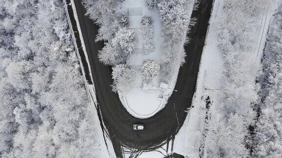 鸟瞰图转向公路在山区冬季积雪覆盖森林