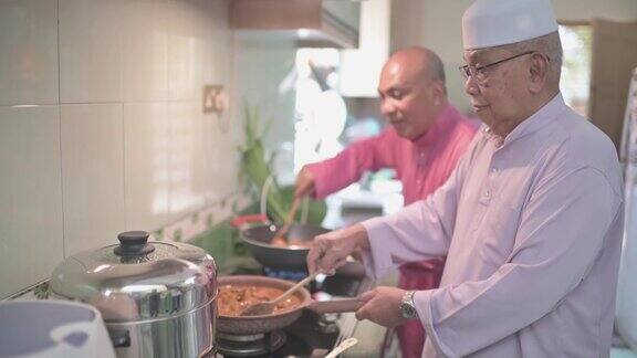 马来家族的祖父和父亲在厨房里并排烹饪传统食物咖喱准备开斋的家庭团圆饭