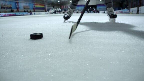 4K慢动作近距离冰球运动员正在练习使用曲棍球棒运球冰上曲棍球溜冰场