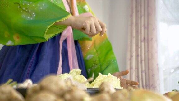 穿着韩服的亚洲妇女正在做泡菜