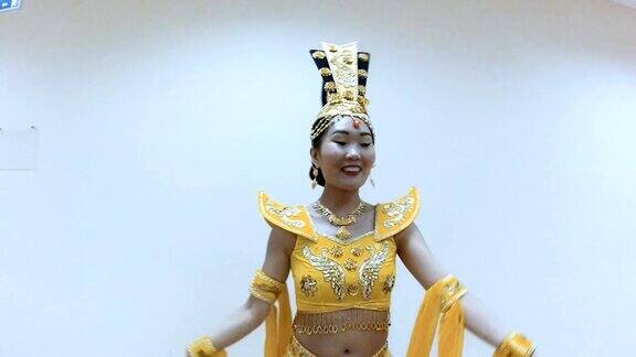 美丽的亚洲女子穿着中国传统的黄色服装跳舞