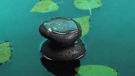 缓慢的运动水滴落在石头堆上树叶漂浮在水面上
