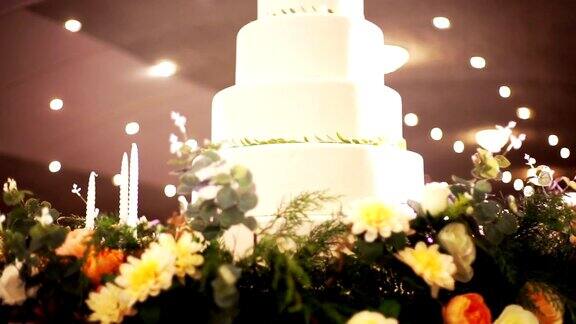 美丽的婚礼蛋糕装饰鲜花和蜡烛在婚宴上