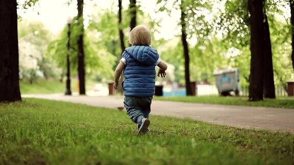 一个快乐的小男孩在公园里跑来跑去