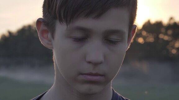 一个生气的悲伤的男孩在麦田里看日落时的镜头