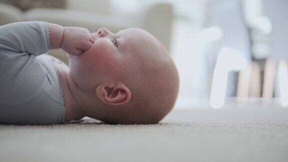 一个4个月大的蓝眼睛男婴躺在地板上