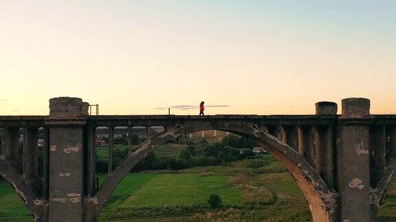 一座巨大的桥一位女士在夕阳下慢跑