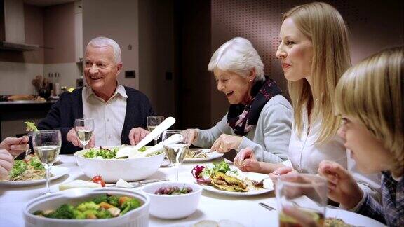 一家人在餐桌上享受着吃饭聊天的乐趣
