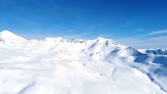 在蓝天下用无人机飞越雪山法国的山顶被雪覆盖着冬天的白色风景令人放松非常适合极限运动