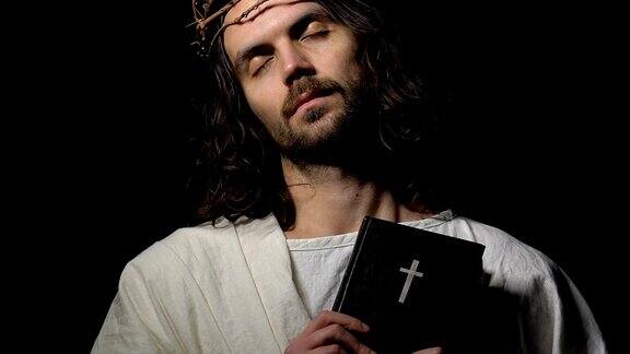 耶稣基督双眼闭在荆棘冠冕上手持圣经钉在十字架上