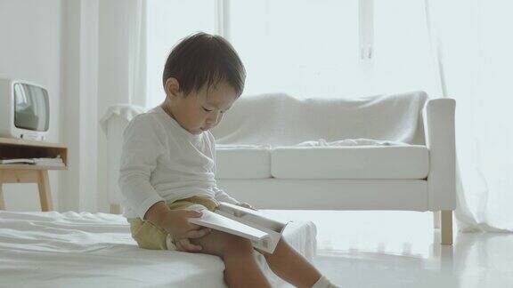 亚洲小男孩在床上看书