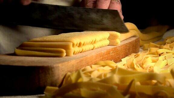 自制新鲜意大利面:在木桌上用传统刀切意大利面