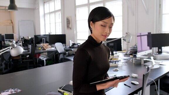 在办公室里用平板电脑的亚洲女商人