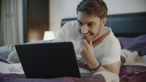 快乐的人在家里用笔记本电脑微笑的男人在笔记本上聊天