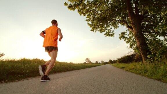 SLOMOTS男性跑步者在日落时穿过乡村