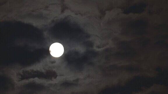 满月被流动的云遮住了一部分