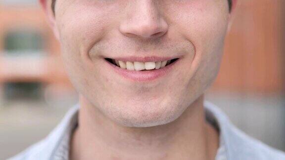年轻男子微笑的嘴唇和牙齿的特写