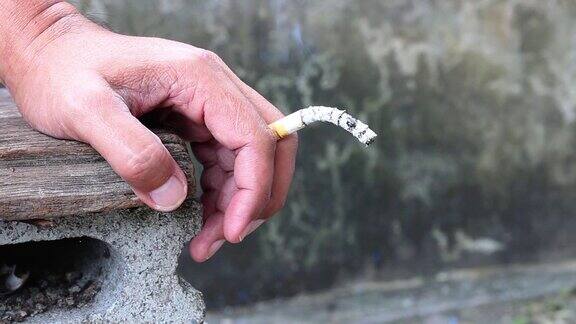一个男人手里拿着香烟特写一名男子手里拿着香烟
