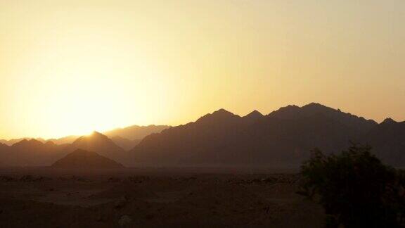 从车窗可以看到山上的日落在路上开车徒步旅行沙漠