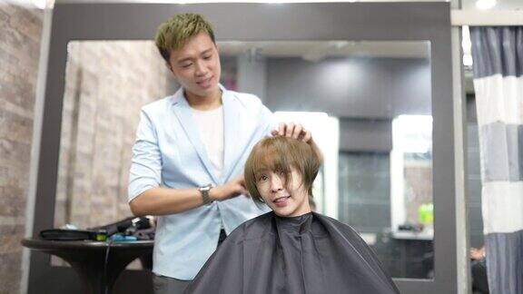 亚洲华人女顾客摇着她的头发美发师为她做最后的造型