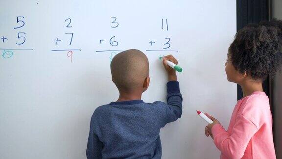 两个非裔美国孩子在白板上做数学题