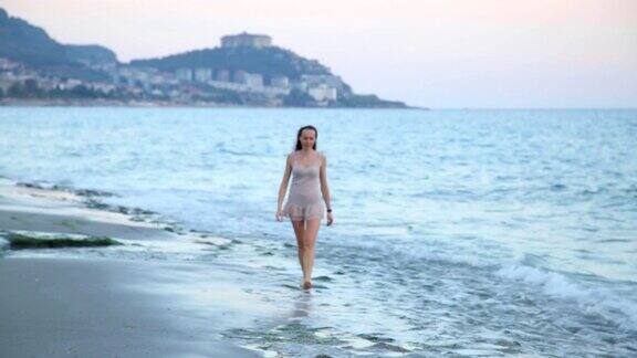 旅行美丽的女孩独自在海滩上