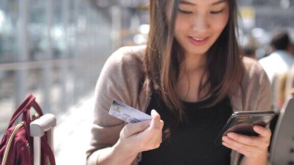 年轻女子用信用卡在智能手机上购物