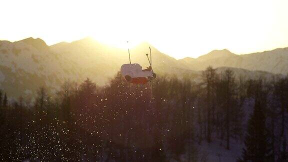 自由式滑雪者在日落时表演一个戏法