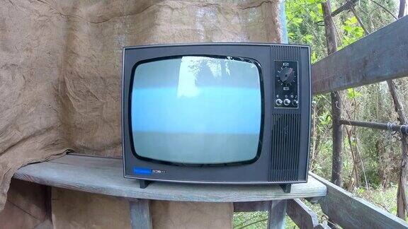 旧电视是用手打开的闪烁的复古电视屏幕打开和关闭