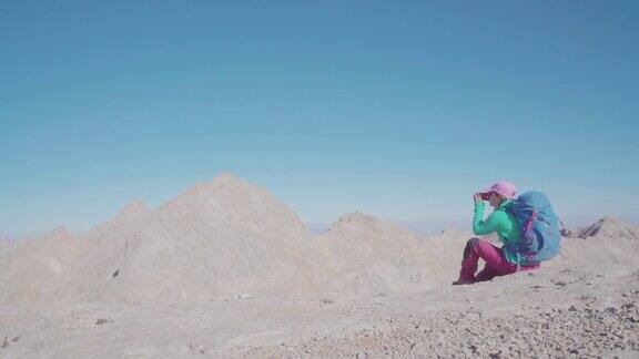 一位女登山者正在山顶上喝咖啡