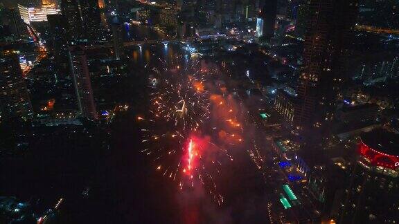 空中无人机视角多色烟花表演在天空之城除夕摩天大楼和城市景观庆祝夜晚的灯光