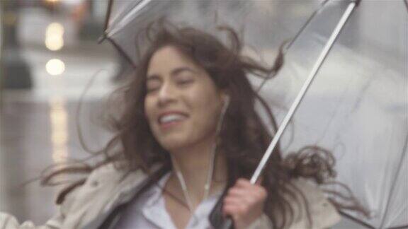 年轻美丽的拉丁女子一边听音乐一边撑着伞在城里跳舞然后她走出画框
