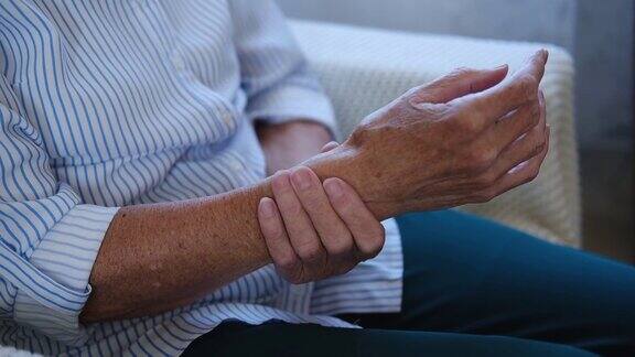 老手老年妇女的特写按摩从关节疼痛和感觉受伤患有风湿性关节炎的老奶奶年长的成年女士触摸手腕骨关节炎