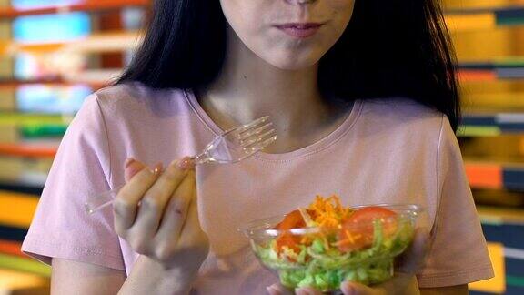 面带微笑的女孩在镜头前享受新鲜蔬菜沙拉健康饮食