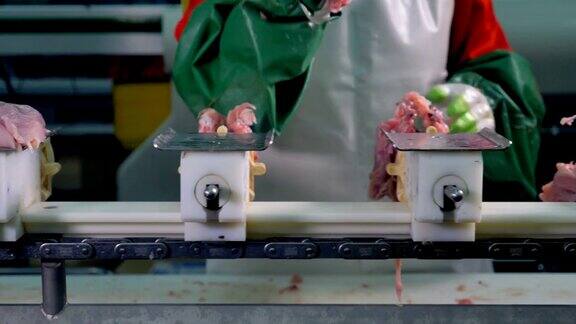 一名工人用手将鸡胸肉从骨头中取出