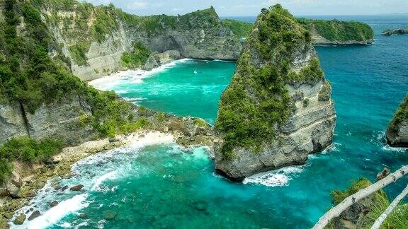 在印度尼西亚巴厘岛北海岸NusaPenida翻滚的海浪悬崖和底部清澈透明的海水的沙滩的美丽景色