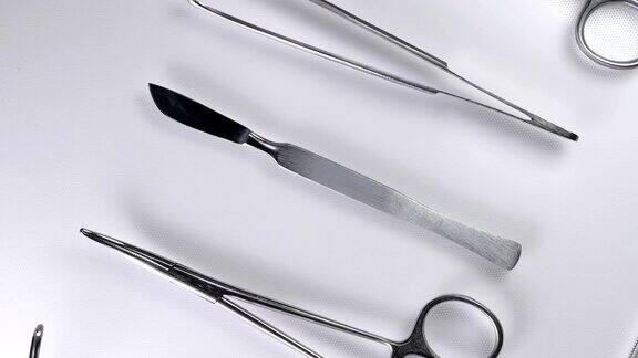 医生从手术台上拿起手术刀和手术器械特写