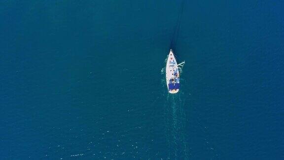 4K无人机实时拍摄宁静、阳光明媚的蓝色海洋上的帆船