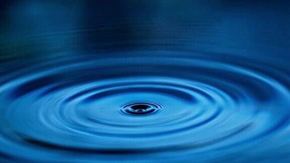 水滴落下在蓝色的水面上泛起涟漪