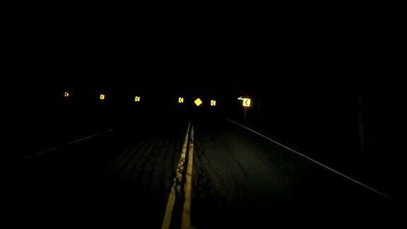 在漆黑的夜里行驶着弯弯曲曲的乡村公路